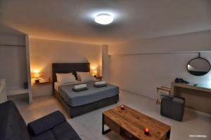 1 dormitorio con cama, sofá y mesa en Sisi seaview apartments, en Sissi