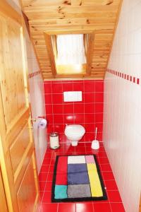 La salle de bains est pourvue de toilettes et de carrelage rouge. dans l'établissement Gasthaus Stefaner, à Feistritz im Rosental