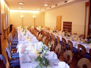 a long dining room with white tables and chairs at Gasthaus Stefaner in Feistritz im Rosental