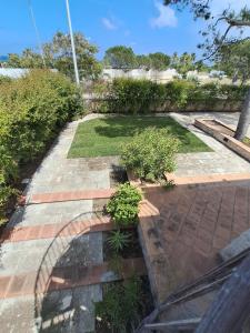 a garden with plants on a brick walkway at Villa Rossi in Polignano a Mare