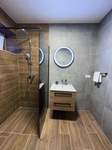 uma casa de banho com um lavatório e um chuveiro em Holiday Home Vrkic with Hot Tub em Omiš