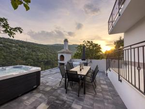 a patio with a table and chairs and a bath tub at Holiday Home Vrkic with Hot Tub in Omiš