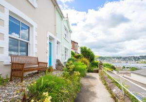 a bench sitting on the side of a house at Oystershell Cottage in Kingswear