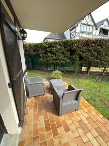 een patio met 2 stoelen en een tafel bij Cabourg - Appartement - 4 pers - 1 ch - Piscine in Cabourg