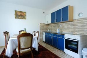 una cocina con armarios azules y una mesa frente a una mesa en The Cosmic Gate 3, en Biskupići