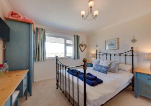 a bedroom with a black bed and a desk at Island View in Thurlestone