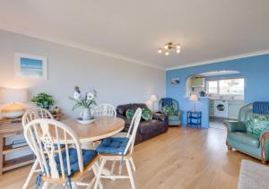 a living room with a table and chairs at Island View in Thurlestone
