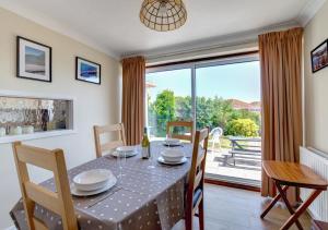 een eetkamer met een tafel en een groot raam bij Bidwell Brook in Paignton