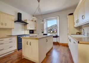 a kitchen with white cabinets and a large window at Number 17 in Dartmouth