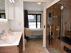 uma casa de banho com um lavatório e um chuveiro e um quarto em Modern holiday home in Maasmechelen with sauna em Maasmechelen