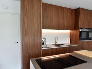 uma cozinha com armários de madeira e um lavatório em Modern holiday home in Maasmechelen with sauna em Maasmechelen