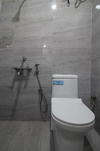 a bathroom with a toilet and a shower at Arjuna Luxury Rooms in Hyderabad
