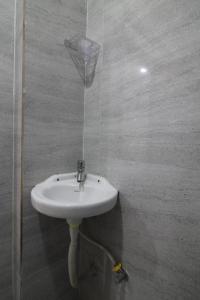 a bathroom with a white sink in a shower at Arjuna Luxury Rooms in Hyderabad