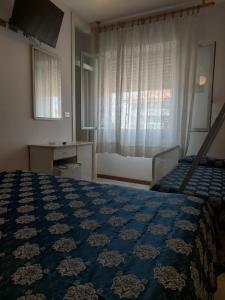 ein Schlafzimmer mit einem blauen Bett und einem Fenster in der Unterkunft Hotel Venus in Riccione