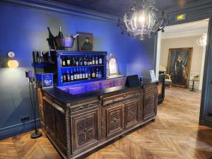 een bar in een kamer met een blauwe muur bij Hôtel du Château du Bois-Guibert in Bonneval