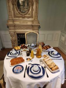 a table with bread and other food on it at Hôtel du Château du Bois-Guibert in Bonneval