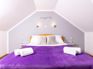 Un dormitorio con una gran cama morada con almohadas blancas. en Apartments Vela Stiniva en Zastražišće