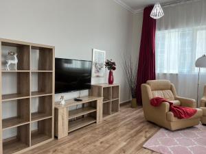 a living room with a flat screen tv and a chair at Two Continents Holiday Homes - Upgraded two bedroom apartment in Dubai