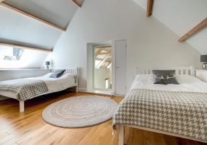 a attic bedroom with two beds and a rug at South Cuma in Drewsteignton