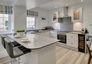 een keuken met witte kasten en een groot eiland bij Saltrock Cottage in Kingsbridge