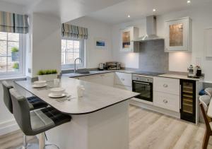 a kitchen with white cabinets and a large island at Saltrock Cottage in Kingsbridge