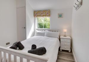 a bedroom with a large white bed with a window at Saltrock Cottage in Kingsbridge