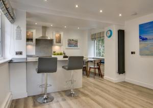 a kitchen and dining room with a counter and chairs at Saltrock Cottage in Kingsbridge