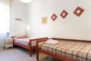 a bedroom with two beds and a wall with pictures on the wall at Re Lear - 4 bedrooms Apartment in Verona