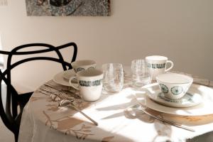 una mesa con platos y tazas y vasos. en Lodge du Hautacam en Ayros-Arbouix