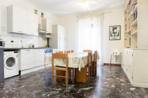 cocina con mesa, sillas y lavadora en Re Lear - 4 bedrooms Apartment, en Verona
