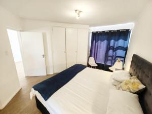 Un dormitorio con una cama grande y una ventana en Paulshof Sandton Apartments - Central Square Complex en Sandton