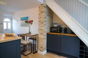 a kitchen with blue cabinets and a brick wall at Luxury holiday home in central Truro in Truro