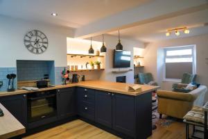 a kitchen with black cabinets and a clock on the wall at Luxury holiday home in central Truro in Truro