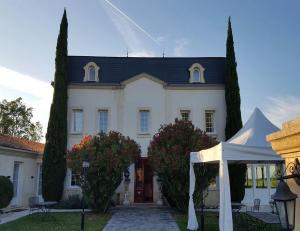 a white house with a tent in front of it at Hôtel de Margaux in Margaux