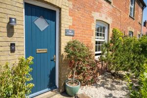 niebieskie drzwi na boku budynku z cegły w obiekcie Hall Cottage Bramfield Suffolk w mieście Bramfield