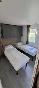um quarto com duas camas e uma janela em Mobilna hiška Hupi em Velenje