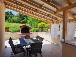 a patio with a table and chairs and a fireplace at Apartmani "Sandro" Gonar in Rab