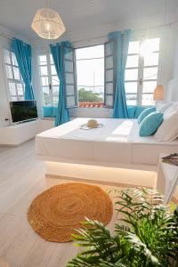 1 dormitorio grande con 1 cama grande y cortinas azules en The White Rose Apartment, en Poros
