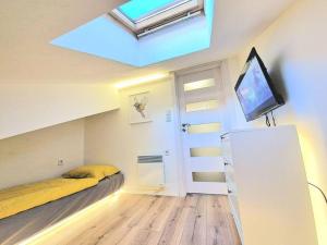 a bedroom with a bed and a tv and a skylight at Art Apartment + 2BD parking space in Varna City