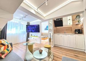 a large living room with a table and a tv at Art Apartment + 2BD parking space in Varna City +23 photos