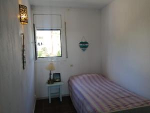 een kleine slaapkamer met een bed en een raam bij Playa de Aro in Platja  d'Aro