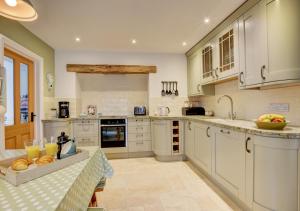 a large kitchen with white cabinets and a counter top at Riverside House in South Pool