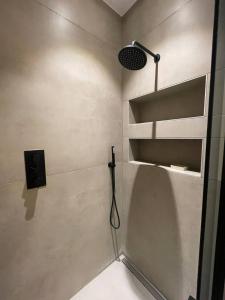 a bathroom with a shower with a light and a shelf at Sleek & Central 1BD Flat - Battersea Park in London