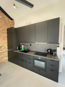a kitchen with gray appliances and a brick wall at Sleek & Central 1BD Flat - Battersea Park in London