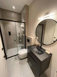 a bathroom with a sink and a toilet and a mirror at Sleek & Central 1BD Flat - Battersea Park in London