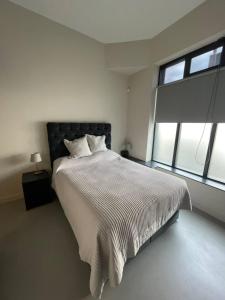 a bedroom with a bed and a large window at Sleek & Central 1BD Flat - Battersea Park in London