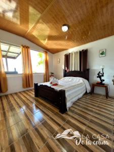 San RafaelにあるVista al Volcán Tenorio y Montañaの木製の天井が特徴のベッドルーム1室(ベッド1台付)