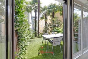 a patio with a table and chairs on the grass at Lugano Center - Apartment for 6 PEOPLE with TERRACE -By EasyLife Swiss in Lugano