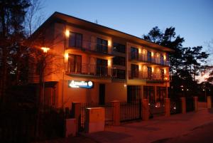 a building with lights on the side of it at night at Villa Amelia in Niechorze