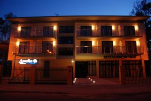 a building with a sign in front of it at night at Villa Amelia in Niechorze +2 photos